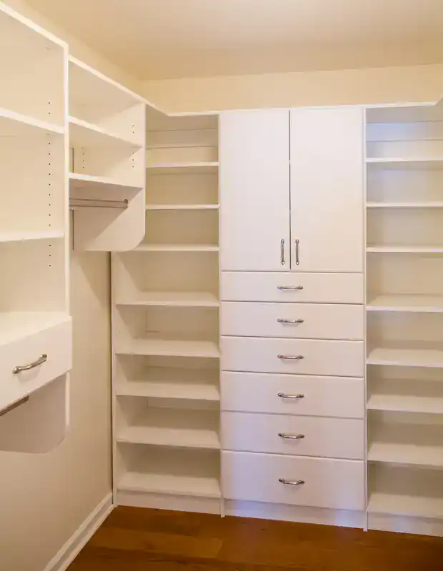White built-in closet featuring shelves and drawers, suitable for cabinet restoration in Suffolk County, NY.