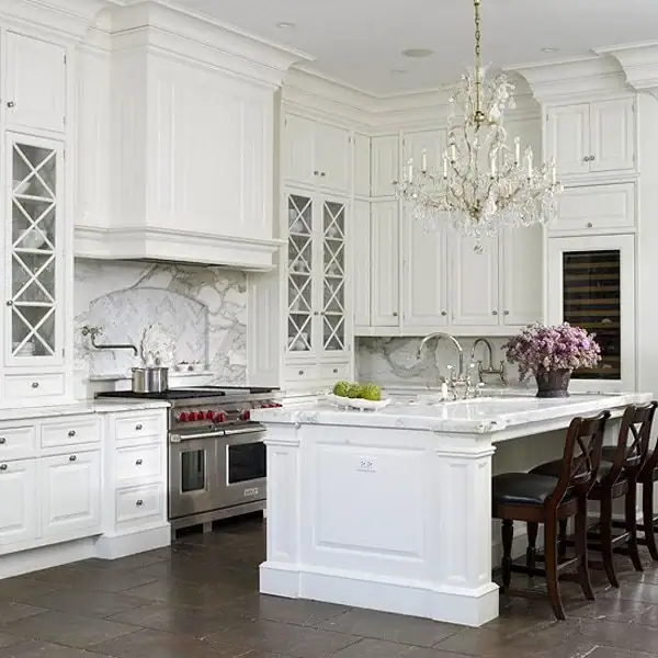 Elegant white kitchen in Suffolk County features marble countertops, island seating, and stainless appliances.